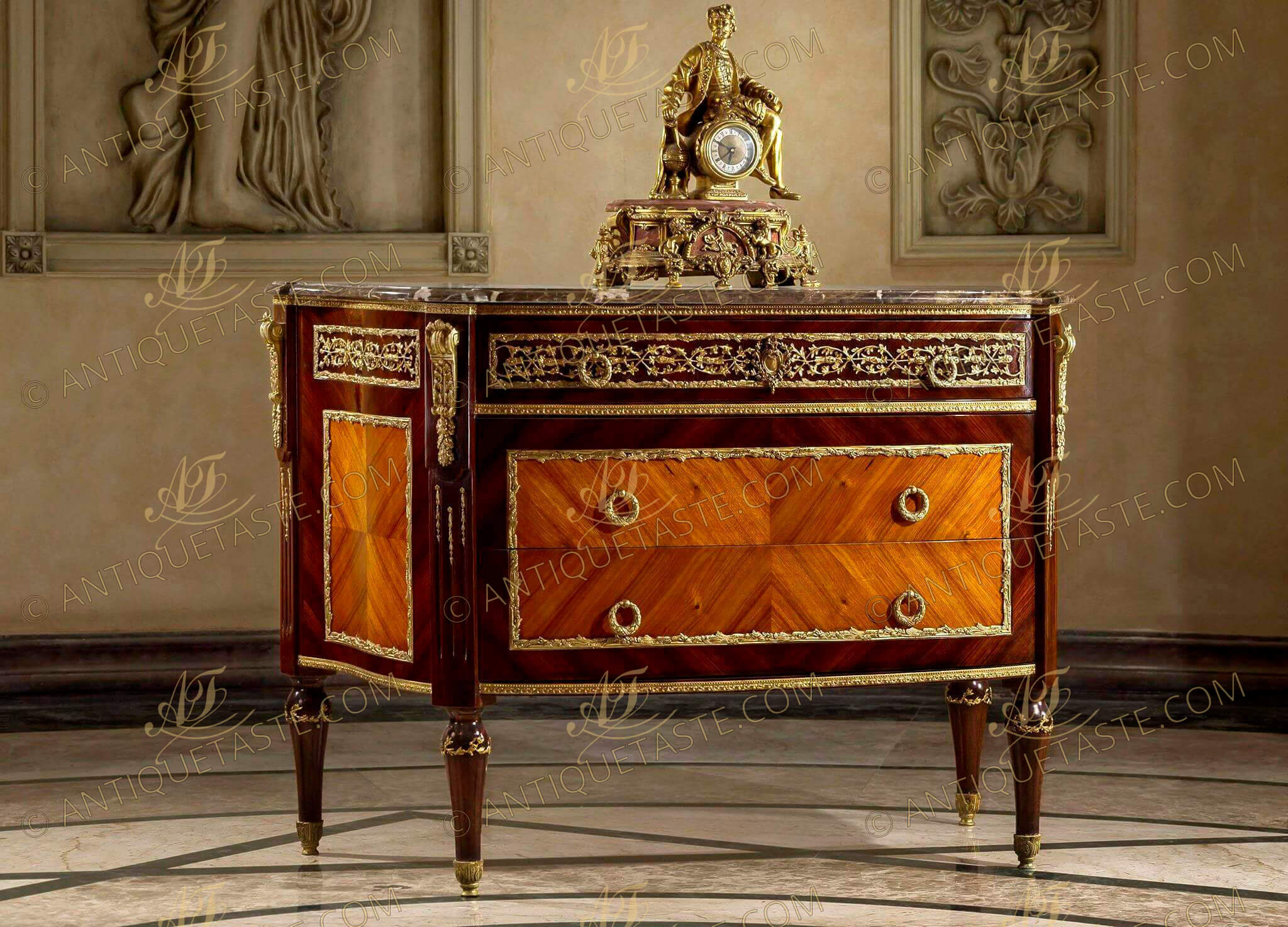 A Louis XVI style gilt-ormolu mounted quarter veneered commode after the model by Jean-Francois Leleu and François Linke Paris, circa 1900 Of D form surmounted by a fine veined eared marble top, above a panelled ormolu-vine-mounted frieze drawer, and boxwood stringing above a pair of quarter-veneered panelled drawers with reeded ring handles all within fine foliage ormolu encadrement, the fluted angles ornamented with ormolu floral chandelles and headed with scrolled acanthus and oak-leaf clasped volutes, on ormolu ornamented circular tapering legs terminating in acanthus-capped feet